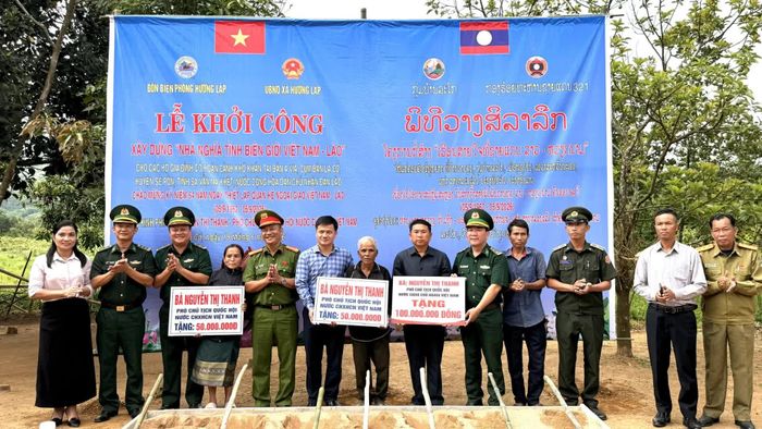 Các hộ dân tại bản A Via, cụm bản La Cồ, tỉnh Sạ-vẳn-na-khệt nhận biển tượng trưng hỗ trợ xây dựng nhà ở - Ảnh: Hoàng Hùng