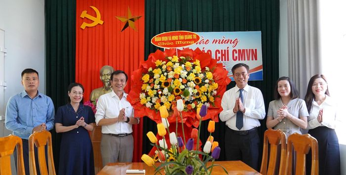 Đồng chí Phó Bí thư Tỉnh ủy, Chủ tịch HĐND tỉnh Nguyễn Đăng Quang tặng hoa chúc mừng phóng viên Văn phòng thường trú Báo Nhân Dân tại Quảng Trị- Ảnh: C.H