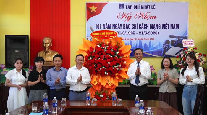 Đồng chí Phó Bí thư Tỉnh ủy, Chủ tịch HĐND tỉnh tặng hoa chúc mừng tập thể cán bộ, nhân viên Tạp chí Nhật Lệ - Ảnh: C.H