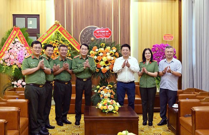 Thứ trưởng Lê Quốc Hùng trao tặng lẵng hoa chúc mừng Báo Nhân dân.