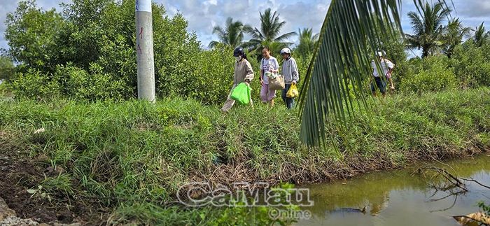 Người dân phải đi bộ và di chuyển vòng qua khu vực phía trong do tuyến lộ bị sạt lở, chia cắt ở ấp Nam Chánh.