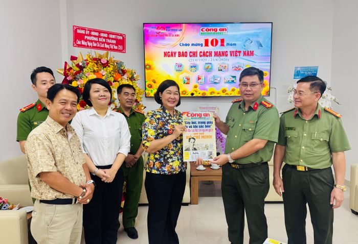 Đại tá Bùi Ngọc Giáp, Bí thư Đảng ủy, Trưởng Ban Chuyên đề CATP tặng bà Hoàng Tố Nga tờ báo phát hành dịp 21/6 năm nay