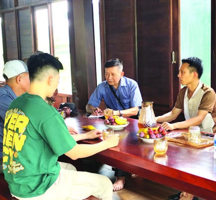 Nhà báo Ngô Đức Hành (thứ 2 bên phải) tìm hiểu về phương pháp nuôi hươu sao ở HTX Hươu sao Ngọc Linh.