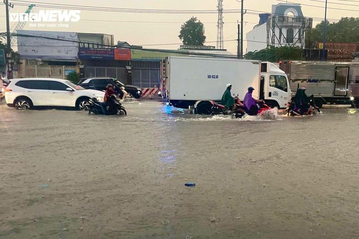 Anh Hoàn Hữu, ngụ phường Bình Hòa cho biết, chỉ sau khoảng 30 phút mưa lớn, nước đã tràn kín mặt đường. "Mưa lớn quá nên tôi dừng lại trú, chờ mưa tạnh, nước rút mới về", anh Hữu nói. 