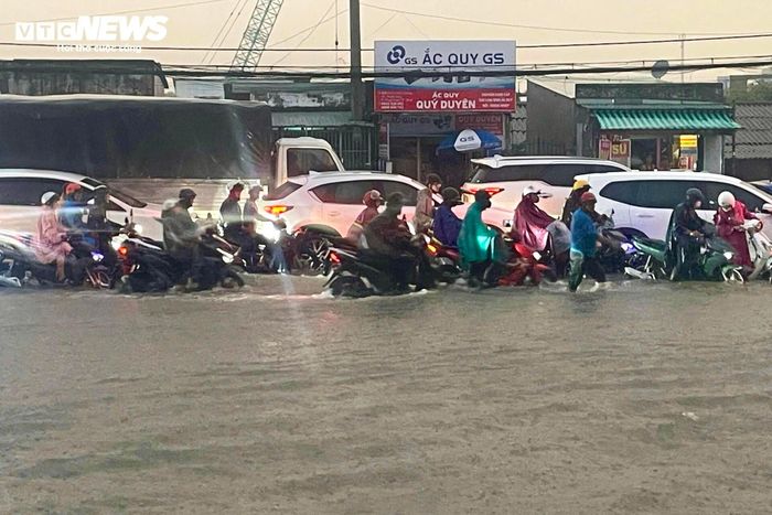 Ô tô con, xe tải, xe khách cũng nối đuôi nhau di chuyển chậm giữa dòng nước. Đoạn đường ngập dài i hàng trăm mét khiến giao thông qua khu vực ùn ứ trong nhiều giờ.