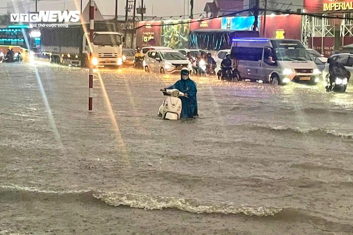Người dân bì bõm đẩy xe về nhà.