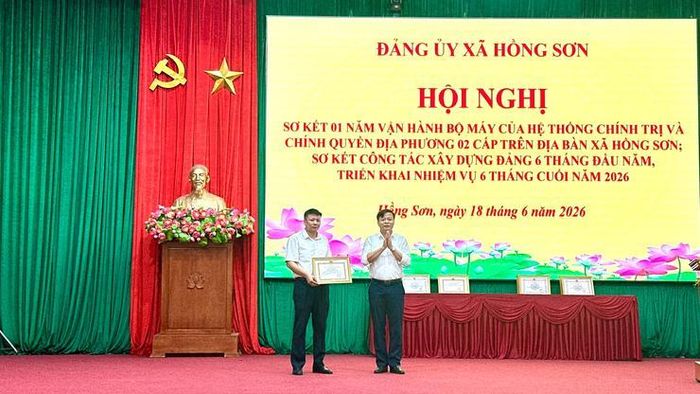 Bí thư Đảng ủy, Chủ tịch HĐND xã Lê Chí Hòa trao Bằng khen của UBND thành phố cho Phó Bí thư Thường trực Đảng ủy xã Nguyễn Văn Hải. Ảnh: Nguyễn Cường