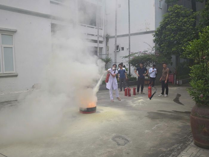 Nhân viên y tế, lực lượng phòng cháy, chữa cháy cơ sở thực hành sử dụng bình chữa cháy xách tay dập tắt đám cháy giả định. Ảnh: N.M