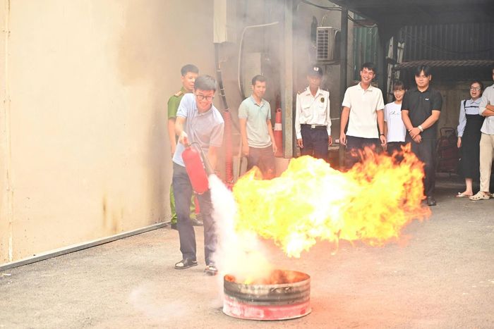 Nhân viên khối văn phòng thực hành sử dụng bình chữa cháy.. Ảnh: Hoàng Trang