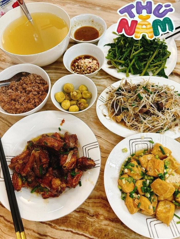 Mâm cơm một ngày giữa tuần tràn ngập hương vị với đĩa sườn xào chua ngọt lên màu cánh gián đẹp mắt và đĩa giá đỗ xào lòng mề gà giòn sần sật. Sự kết hợp giữa thịt băm chưng và đậu phụ rán tẩm hành hoa tạo nên một bữa tiệc vị giác tuy giản dị nhưng vô cùng kích thích. Dù bận rộn với công việc kinh doanh, bà xã Hồng Đăng vẫn duy trì thói quen tự tay đứng bếp để giữ lửa tổ ấm.
