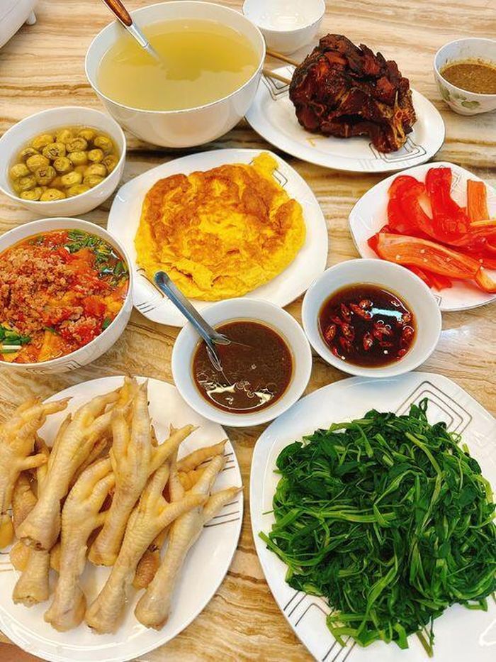 Bữa cơm đúng chất Việt Nam, nào cá kho đậm đà, trứng rán vàng ươm, canh bổ dưỡng, đi kèm chân gà luộc, rau muống xanh mướt, thêm bát cà pháo muối chua chua giòn rụm.