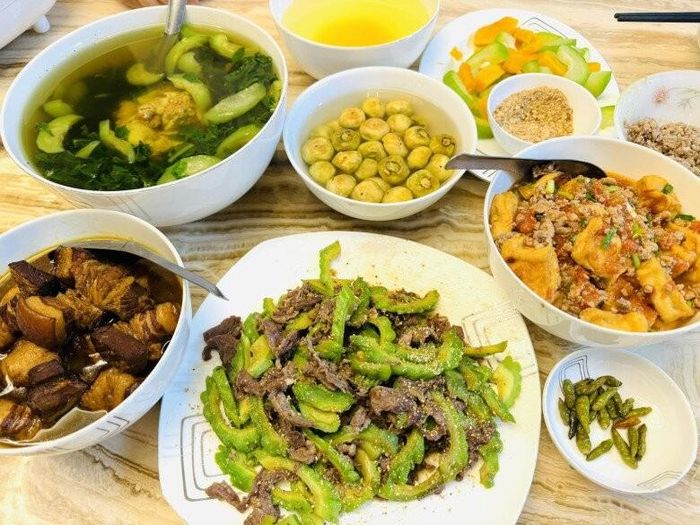 Một mâm cơm chuẩn vị Bắc với bát thịt kho tàu chuẩn chỉnh, miếng thịt mềm rục, ngập trong nước sốt sóng sánh ăn kèm cà pháo muối chua. Đĩa mướp đắng xào thịt bò rắc tiêu thơm phức kết hợp với bát canh mướp nấu rau mồng tơi ngọt lịm giúp thanh nhiệt cơ thể hiệu quả.