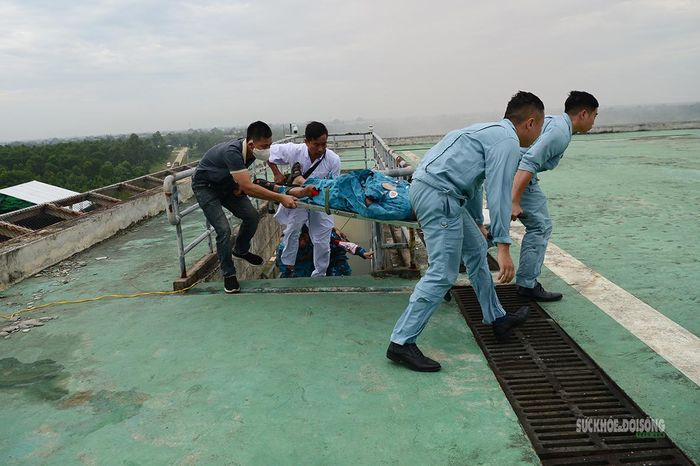 Lực lượng quân y và cứu hộ đưa nạn nhân lên nóc nhà, chuẩn bị chuyển lên trực thăng.