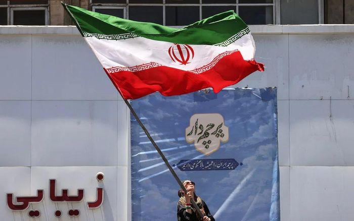 Một người phụ nữ vẫy quốc kỳ Iran tại Quảng trường Valiasr ở Tehran. Ảnh: Atta Kenare/AFP
