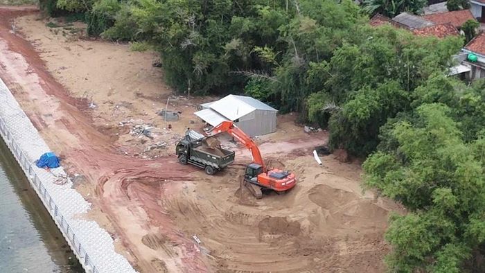 Xe múc công trình chuyển cát lên xe ben chở đi bán sáng 25-7-2025.