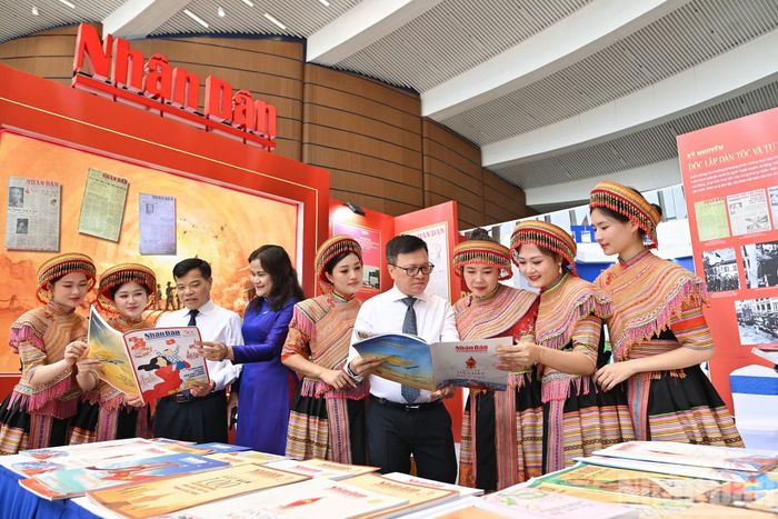 Tổng Biên tập Báo Nhân Dân Lê Quốc Minh với các đại biểu tại gian trưng bày của Báo Nhân Dân.