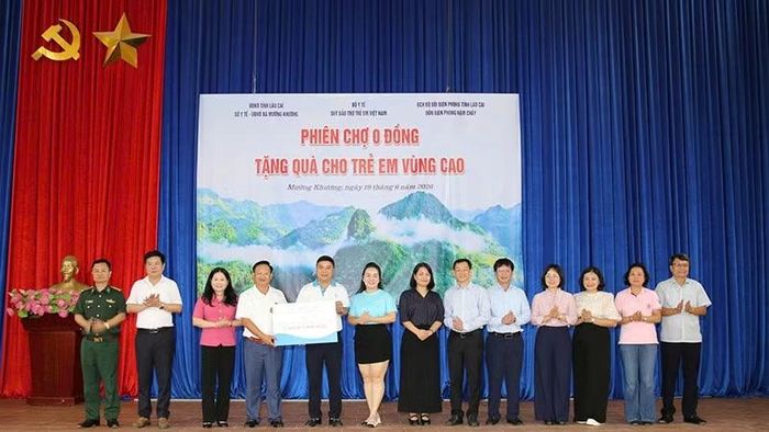 Đại diện Quỹ Bảo trợ trẻ em Việt Nam trao biển tượng trưng gần 2,4 tỷ đồng quà tặng qua “Phiên chợ 0 đồng” cho lãnh đạo xã Mường Khương dưới sự chứng kiến của các đại biểu. (Ảnh BTC)