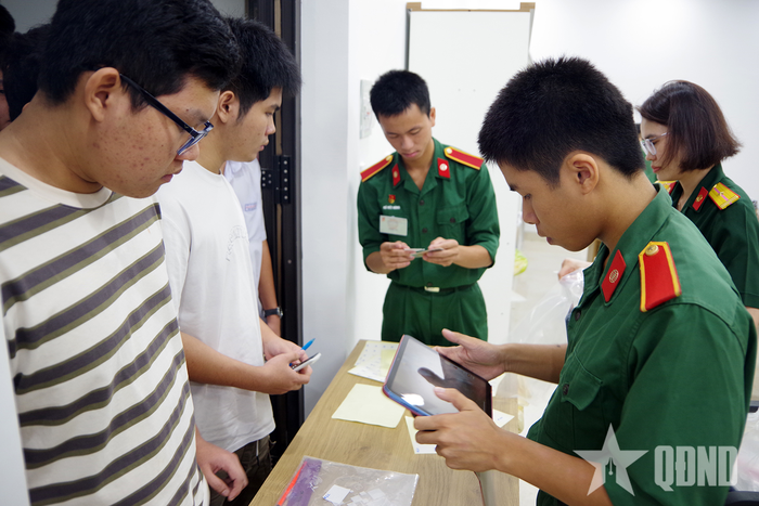 Học viên Trường Sĩ quan Thông tin hướng dẫn thí sinh làm thủ tục thi. 