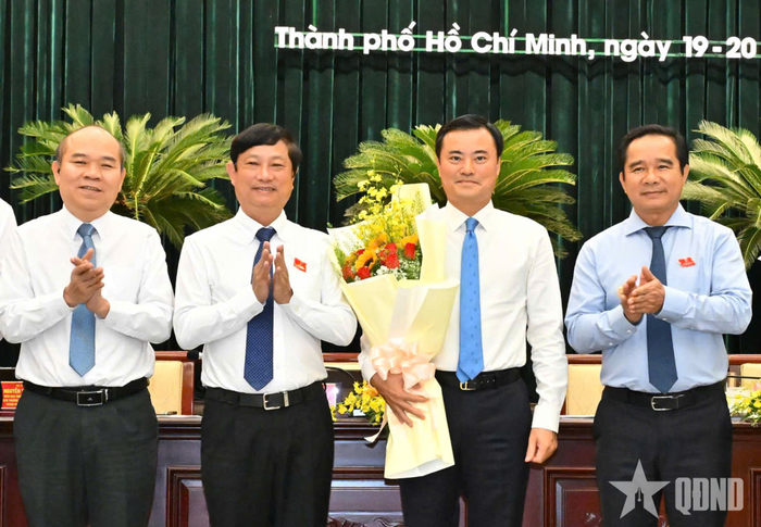 Lãnh đạo TP Hồ Chí Minh tặng hoa cảm ơn những đóng góp của đồng chí Bùi Xuân Cường. Ảnh: VIỆT DŨNG