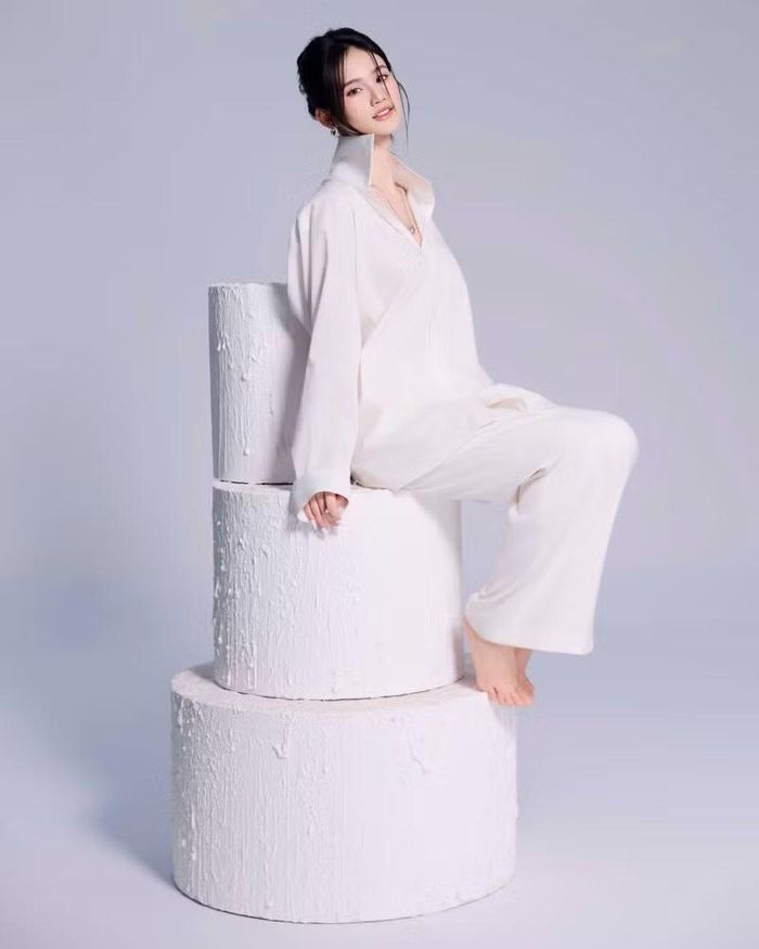 Ở concept thứ hai, Hoa hậu Ý Nhi mang đến hình ảnh nhẹ nhàng, nữ tính với trang phục trắng thanh lịch bên chiếc bánh kem nhiều tầng.