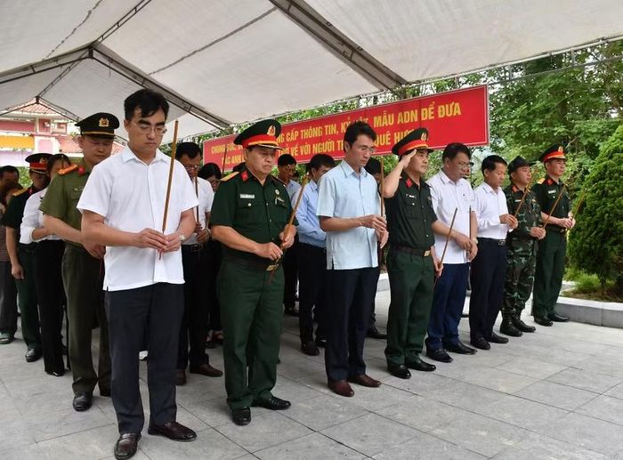 Đại biểu dành một phút mặc niệm trước khi tiến hành quy trình lấy mẫu ADN tại nghĩa trang xã Than Uyên.