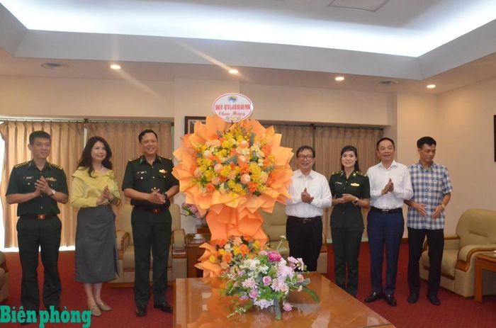 Đại tá Cà Văn Lập (thứ 3, từ trái sang) cùng đoàn công tác tặng hoa, chúc mừng Thông tấn xã Việt Nam. Ảnh: Duy Khiêm