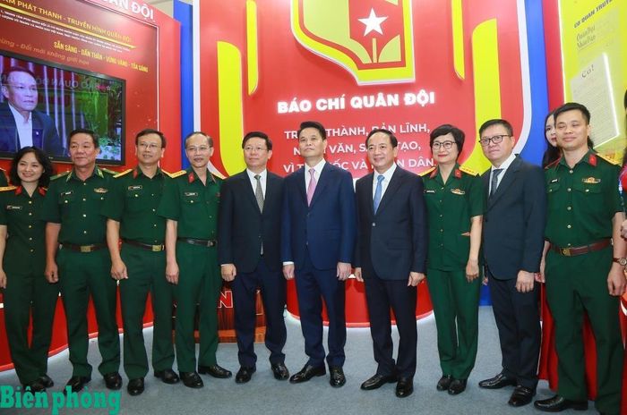 Đồng chí Trịnh Văn Quyết (thứ 4, từ phải sang) cùng các đại biểu chụp ảnh lưu niệm tại gian trưng bày của khối báo chí Quân đội. Ảnh: Cẩm Linh