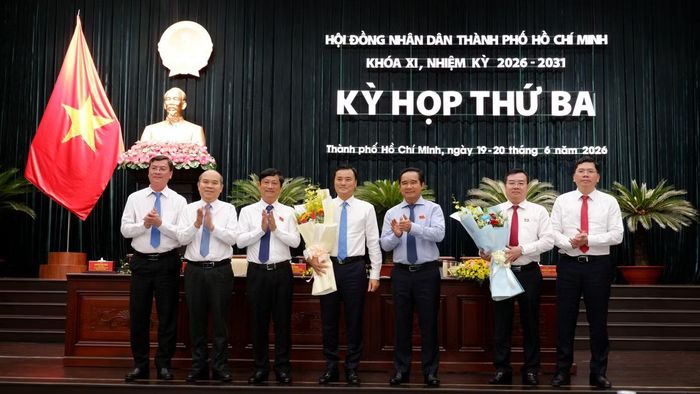 Chủ tịch UBND TPHCM Nguyễn Văn Được, Chủ tịch HĐND TPHCM Võ Văn Minh và các đại biểu tặng hoa cảm ơn ông Bùi Xuân Cường và ông Nguyễn Văn Đồng. Ảnh: Hữu Huy