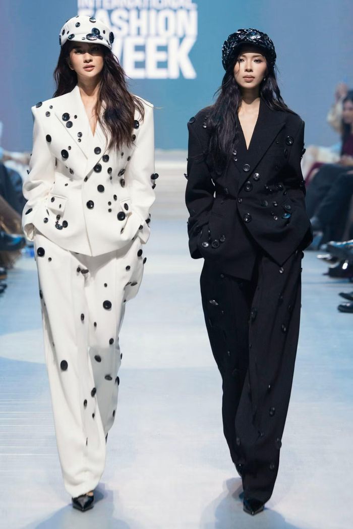 Kim Tuyến và Đồng Ánh Quỳnh đối lập trong suit oversized tông trắng - đen, được nhấn nhá bằng chi tiết đính nút đặc trưng, thể hiện tinh thần unisex hiện đại và cá tính bộ sưu tập.