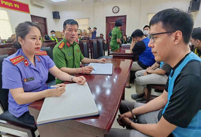 Đối tượng Trần Đạo Tú (ngoài cùng bên phải đeo kính) làm việc với cơ quan công an. Ảnh: CACC