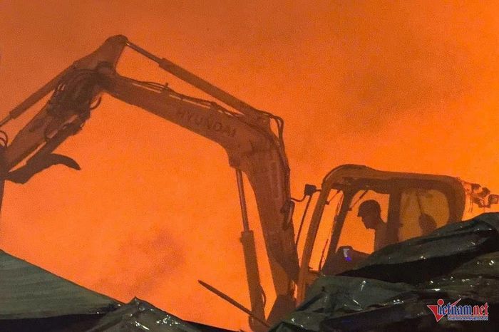 Dù khói lửa bao trùm nhưng các tài xế xe máy múc vẫn lao vào chữa cháy. Ảnh: Hải Dương