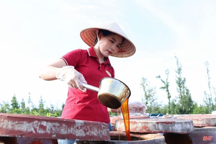 Chị Dương Thị Mến kiểm tra chất lượng nước mắm tại cơ sở sản xuất.