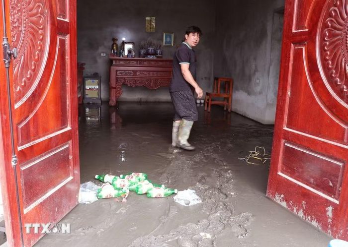 Bùn đất bồi lấp nhà cửa, phương tiện và mặt bằng kinh doanh, ảnh hưởng nghiêm trọng đến đời sống của người dân. (Ảnh: Đức Thọ/TTXVN)
