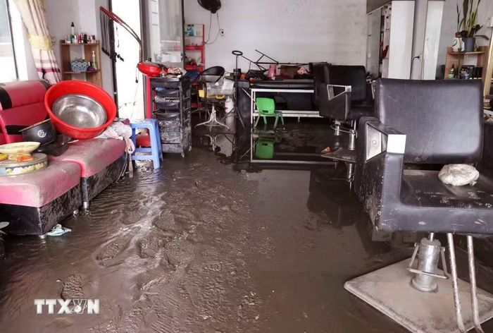 Bùn đất bồi lấp nhà cửa, phương tiện và mặt bằng kinh doanh, ảnh hưởng nghiêm trọng đến đời sống của người dân. (Ảnh: Đức Thọ/TTXVN)