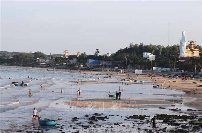 Người dân, du khách vui chơi giải trí trên bờ biển làng chài Phước Thiện.