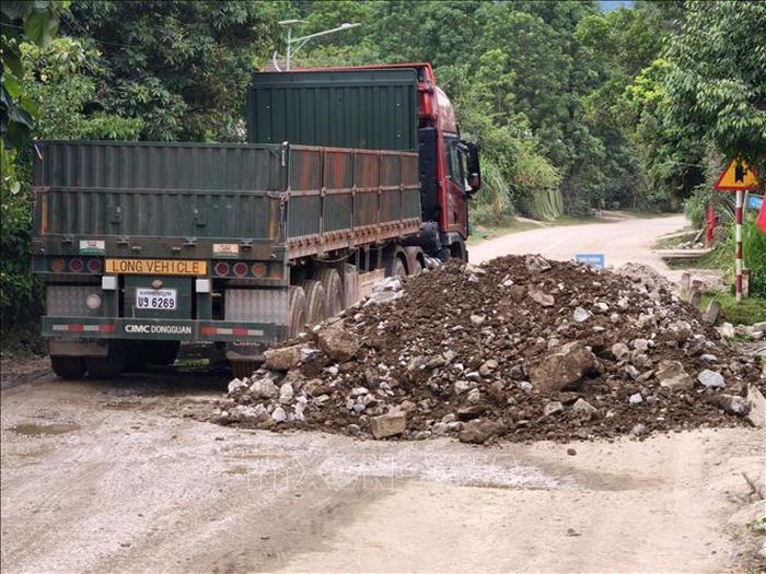 Mỗi ngày có hàng trăm chuyến xe tải trọng lớn đi lại trên tuyến Quốc lộ 14D để chở hàng hóa thông thương qua Cửa khẩu quốc tế Nam Giang. Ảnh: Quốc Dũng/TTXVN