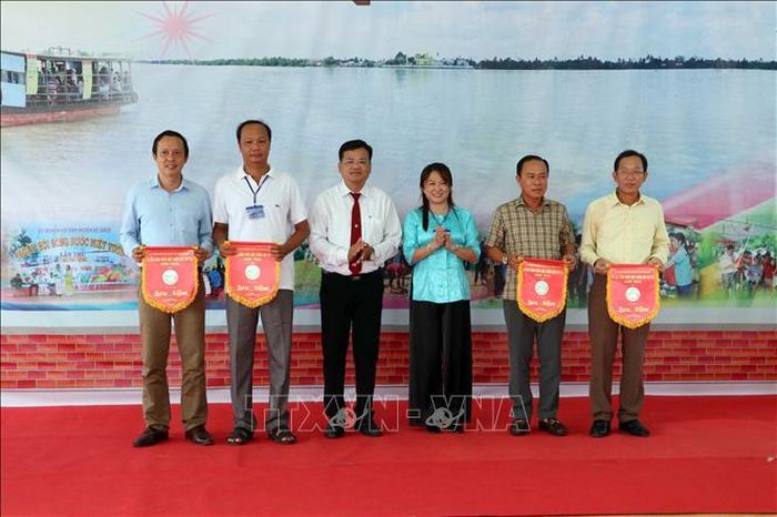 Ban Tổ chức trao cờ lưu niệm cho các đơn vị đồng hành và tham gia Ngày hội.