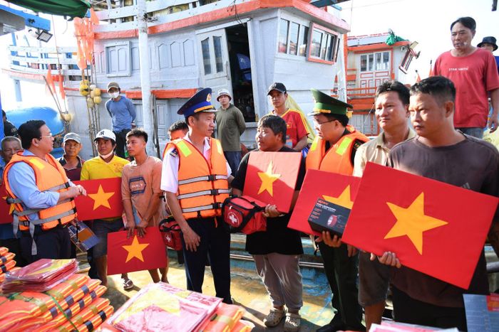 Lãnh đạo Bộ Tư lệnh Vùng Cảnh Sát biển 3 cùng lãnh đạo địa phương trao cờ Tổ quốc, đèn pin, áo phao cho ngư.