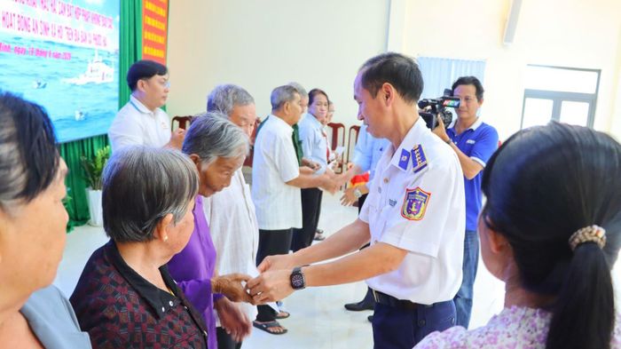 Đai tá Lê Văn Tú, Chính ủy Bộ Tư lệnh Vùng Cảnh Sát biển 3 trao quà cho bàn con ngư dân.