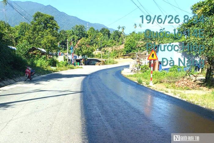 Công nhân thi công lớp keo dính bám trên cầu Bà Lau; cách đó không xa, xe chuyên dụng tưới nhựa dính bám đoạn Km73+600 - Km74+200, Quốc lộ 14E qua xã Phước Hiệp.