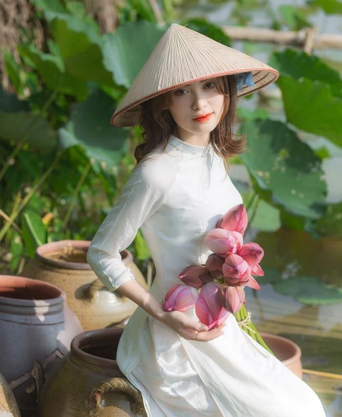 Thiếu nữ diện áo dàng, dịu dàng bên bó hoa sen. Ảnh: Hoàng Anh/báo Bắc Ninh