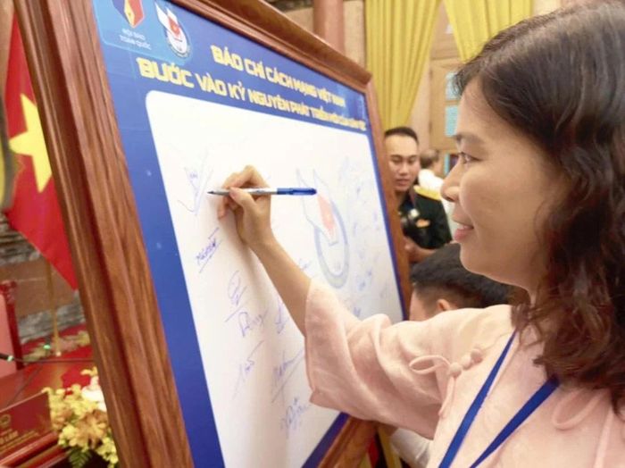 Nhà báo Nguyễn Minh Tuyết ký tên lưu niệm trên bảng biểu trưng kỷ niệm 101 năm Ngày Báo chí Cách mạng Việt Nam. (Ảnh: NVCC)