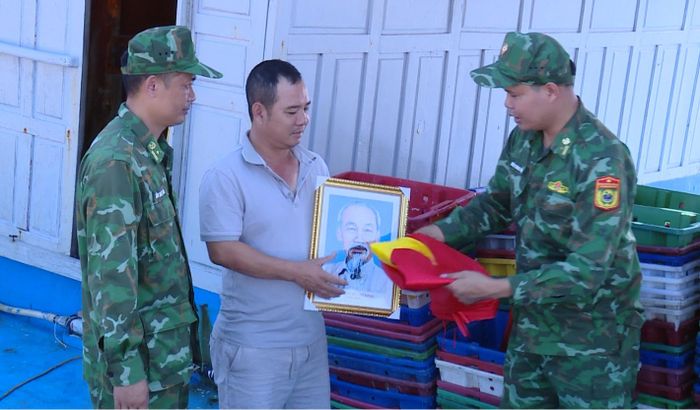 Đồn Biên phòng Hải Hòa tặng ảnh Bác Hồ và cờ Tổ quốc cho chủ tàu Nguyễn Ngọc Hưng.