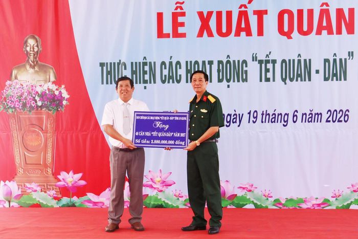 Đại tá Cao Minh Tâm trao bảng tượng trưng hỗ trợ kinh phí xây dựng nhà cho đại diện UBND xã Thạnh Lộc.