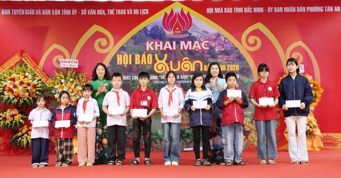 Đại diện lãnh đạo Báo và Phát thanh, Truyền hình Bắc Ninh và Ban chủ nhiệm Câu lạc bộ Nhà báo nữ trao quà cho học sinh phường Tân An.