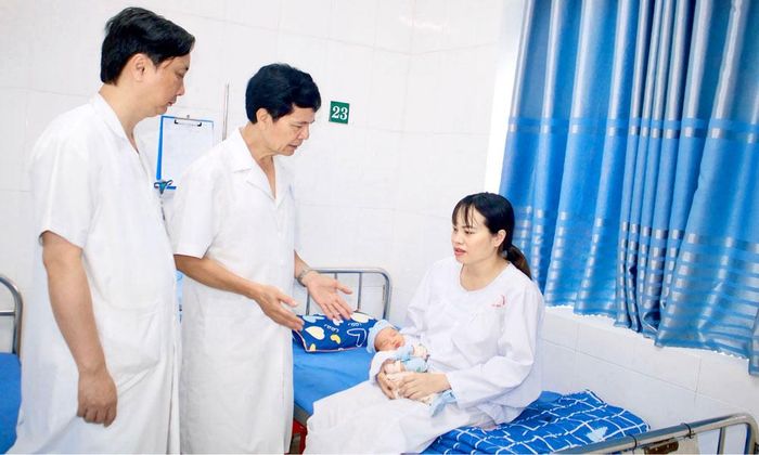 Bác sĩ Lê Công Tước (đứng bên phải) thăm khám cho mẹ con chị Nguyễn Thị Phượng.