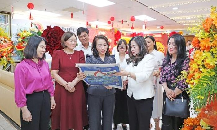  Đồng chí Nguyễn Thị Hương và các đại biểu trao đổi về ấn phẩm của Báo Đại biểu Nhân dân. 