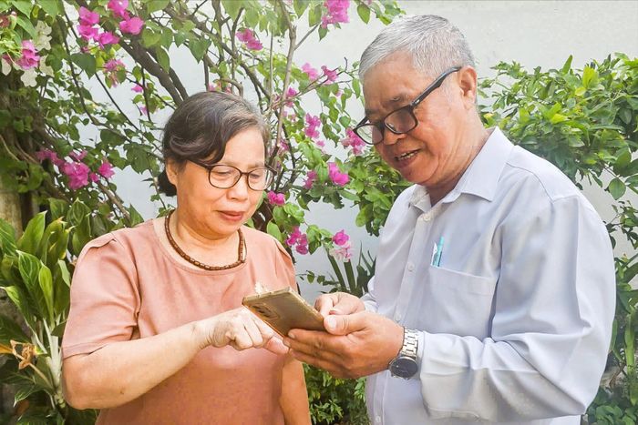 Ông Lê Quý Hiệu, Tổ trưởng tổ dân phố số 36 Hòa An (phường An Khê) hướng dẫn người dân cài đặt ứng dụng trên điện thoại thông minh. Ảnh: NGỌC PHÚ