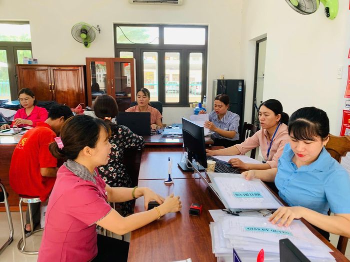Cán bộ, công chức xã Núi Thành hướng dẫn thủ tục hành chính cho người dân. Ảnh: C.Tú