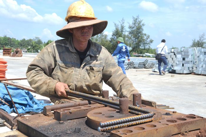 Công nhân uốn sắt thép để làm gờ chắn lan can cầu Trường Giang, thuộc dự án đường trục chính Tam Hòa. Ảnh: CÔNG TÚ